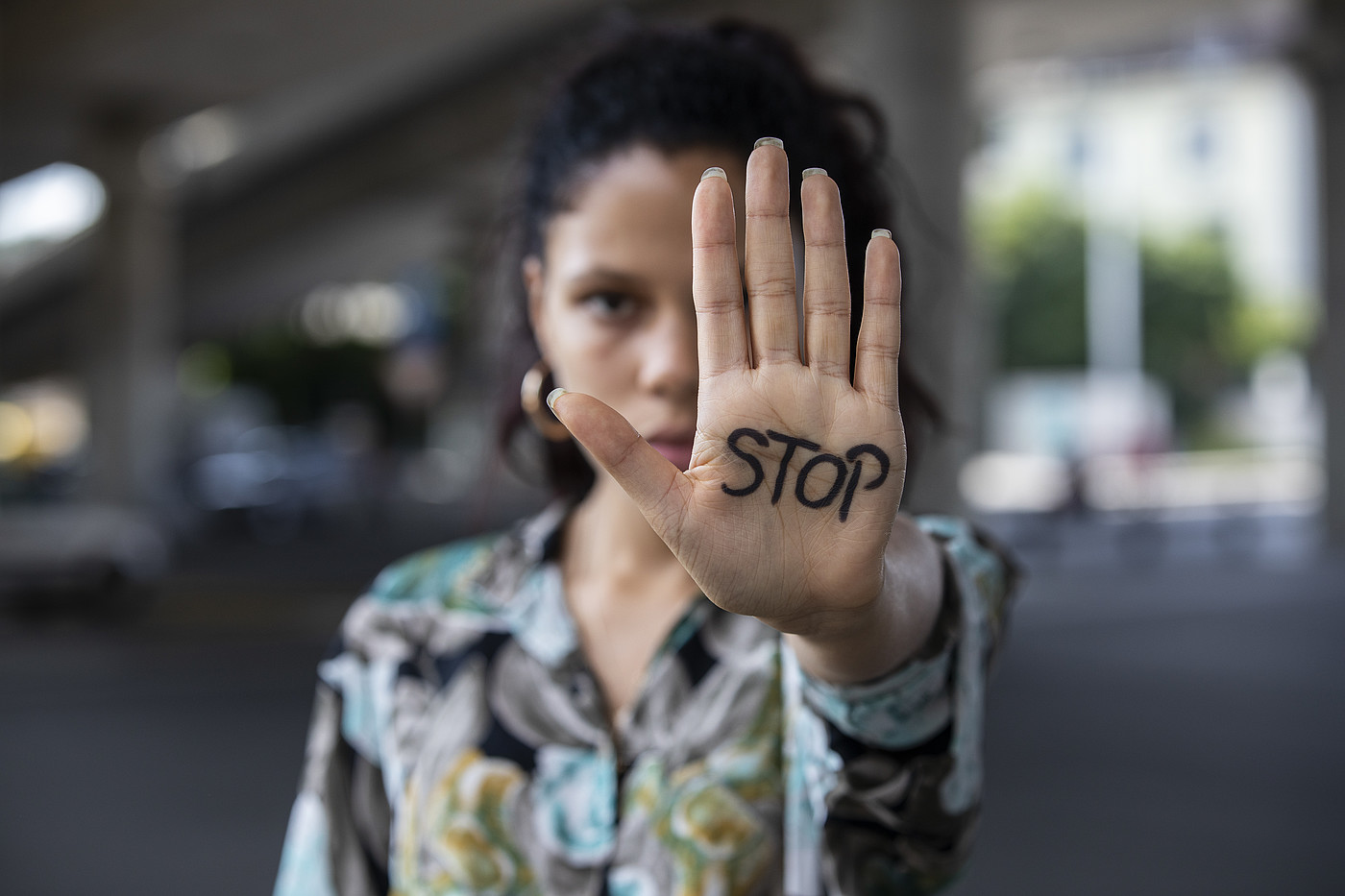 Una giovane donna tende la mano. Dice STOP.