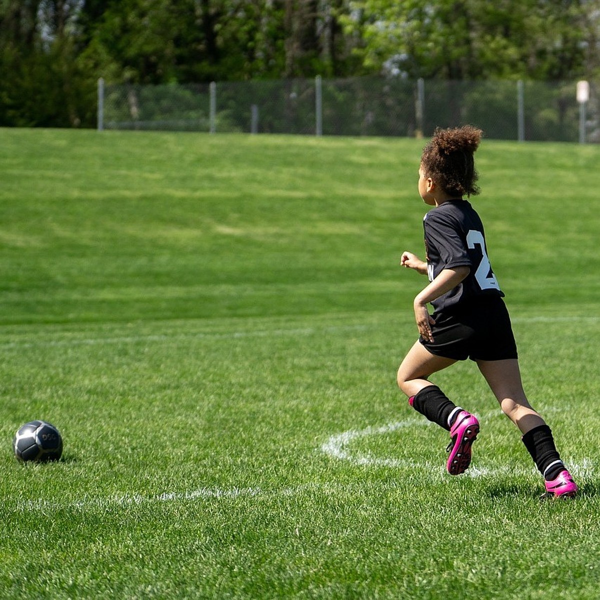 Un bambino che corre dietro a un pallone sul campo da calcio